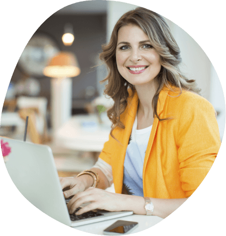 Woman in yellow business jacket typing on laptop