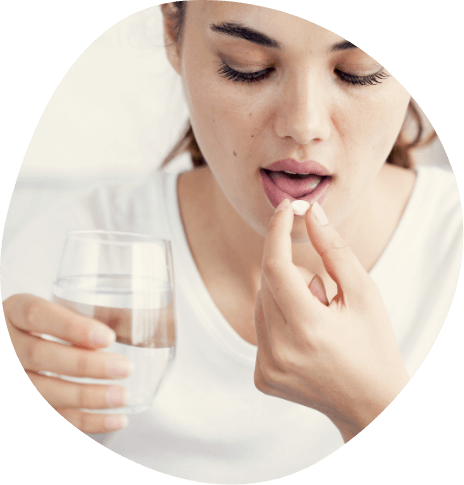 Woman taking pill with glass of water