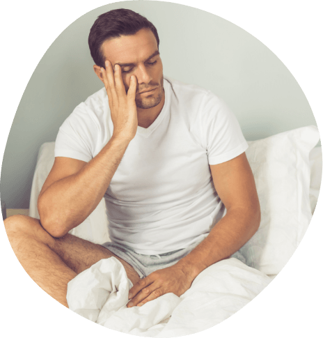 Tired man sitting up in bed