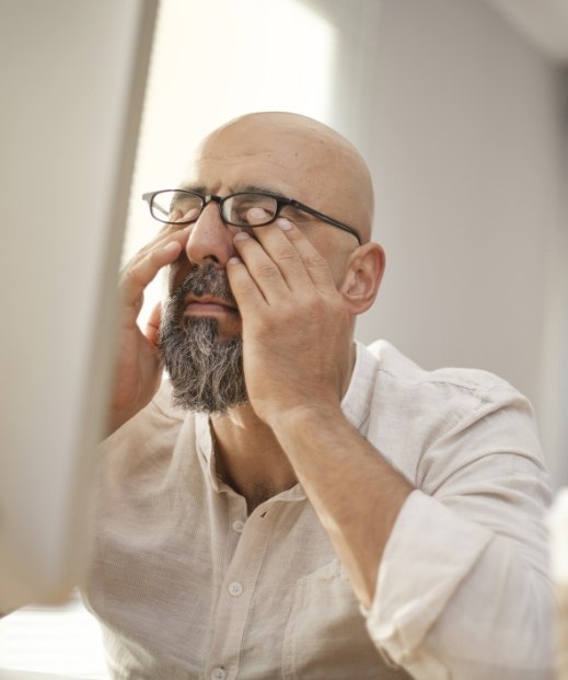 Man with glasses rubbing his eyes before sleep testing in Plano