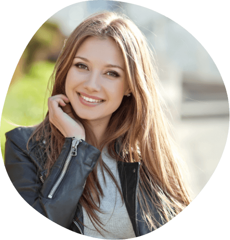 Young woman in black leather jacket smiling outdoors
