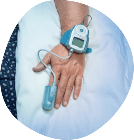Hand of a person in bed wearing a finger sensor