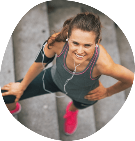 Woman in workout clothes smiling on stone staircase